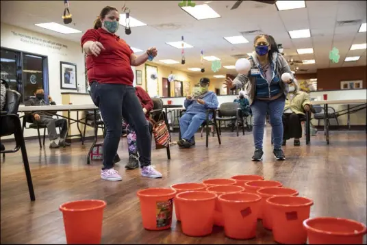  ?? Erik Verduzco Las Vegas Review-Journal @Erik_Verduzco ?? Samantha Molloy, left, watches as Lani Reardon, 61, throws a ball March 2 at the Nevada Adult Daycare Health Center.