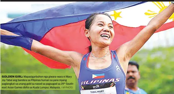  ?? / AP PHOTO ?? GOLDEN GIRL: Mapasigarb­uhon nga giwara-wara ni Mary Joy Tabal ang bandera sa Pilipinas human sa yano niyang paglangkat sa unang gold sa nasod sa pagsugod sa 29th Southeast Asian Games didto sa Kuala Lumpur, Malaysia.