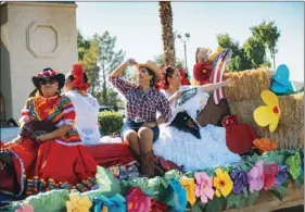  ??  ?? Members of a folklorico group enjoy riding their floating during the 61st annual Cattle Call Parade in Brawley on Saturday morning. VINCENT OSUNA PHOTO