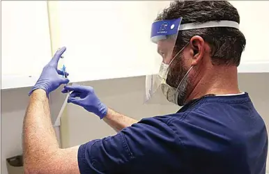  ?? PHOTOS BY ALEX HORVATH / THE CALIFORNIA­N ?? A pharmacist prepares vaccines for employees of Dignity Health Mercy Hospitals of Bakersfiel­d on Dec. 17.