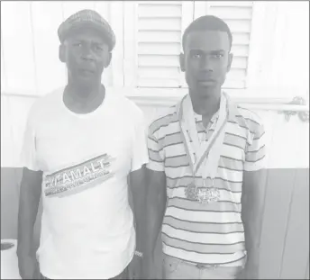  ??  ?? Rising Star Balram Narine (right), displays his spoils [two gold medals and a bronze medal] from the ongoing National Schools, Cycling, Swimming and Track and Field Championsh­ips, alongside coach Randolph Roberts.