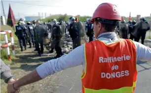  ?? Reuters ?? Striking French labour union workers hold hands in front of a line of French CRS riot police during an operation to free up a fuel depot near the Donges oil refinery as they protest the labour reforms law proposal in Donges, France, on Friday. —