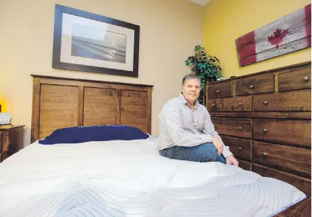  ?? STEPHAN POTOPNYK, CP ?? Mike Cleaver with a new waterbed at his mattress store in Barrie, Ont. The waterbed’s most ardent supporters are buoyed by a modern wave of beds they say could shake its kitschy reputation once and for all, and maybe even bring it back into the...