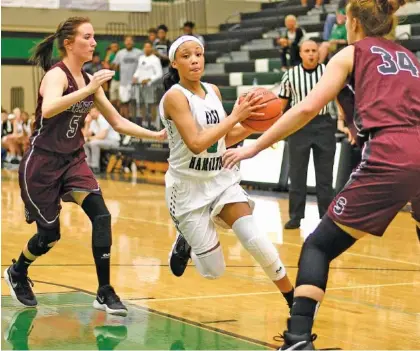  ?? STAFF PHOTO BY ROBIN RUDD ?? East Hamilton’s De’Zah Lacy drives to the basket between two White County players during Friday night’s Region 3-AAA quarterfin­al at East Hamilton. The host Lady Hurricanes won 61-43.