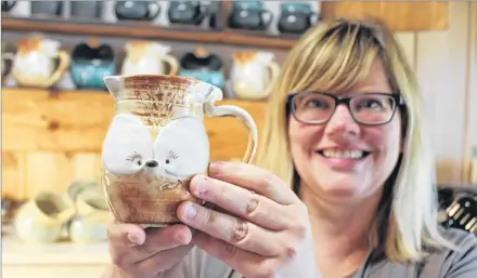  ?? COLIN MACLEAN/JOURNAL PIONEER ?? Crystal Stevens, of Redrocks Pottery in North Bedque, shows off Jax, one of the individual­ly named creations from her PEI Fox Mugs brand.