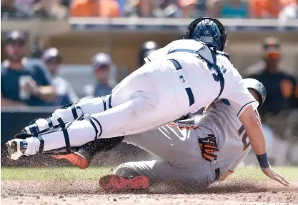  ?? Kelvin Kuo/Associated Press ?? ■ San Diego Padres catcher Austin Hedges, top, tags out San Francisco Giants' Evan Longoria during the eighth inning of a baseball game Tuesday in San Diego.