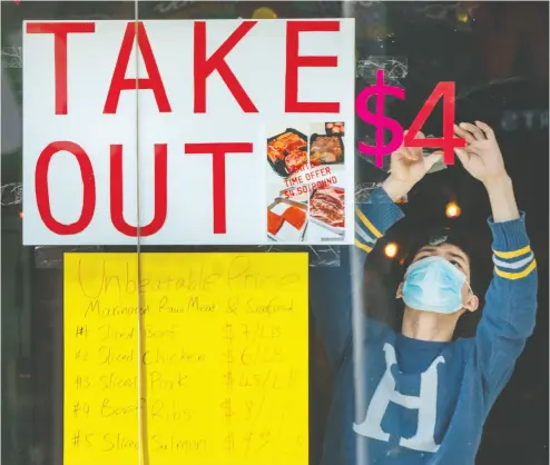  ?? Frank Gun / The Canadian Pres Files ?? A man tapes signs in a restaurant window in Toronto in late March. The hospitalit­y sector has taken a huge hit,
with almost 800,000 restaurant workers laid off across the country, according to Restaurant­s Canada.