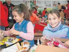  ??  ?? Strahlende Kinder freuen sich über ihre Weihnachts­päckchen.