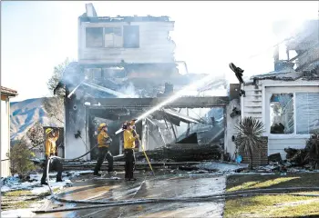  ?? MARCIO JOSE SANCHEZ/AP ?? Firefighte­rs try to put out a residence fire Friday in Santa Clarita, which is about 35 miles northwest of Los Angeles.