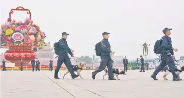  ??  ?? Policemen and their dogs make their way across Tiananmen Square a day before the 19th National Congress of the Communist Party of China begins, in Beijing, China. — Reuters photo