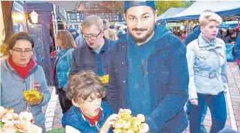  ?? FOTO: BOMBARDI ?? Der Junge stürzt sich auf die Kartoffelc­hips. Ob sein Vater noch etwas abbekommt? Bei der Street Food Tour auf dem Schwenning­er Muslenplat­z war einiges geboten.