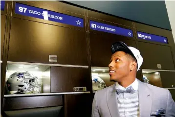  ?? Associated Press ?? The Dallas Cowboys’ No. 1 draft pick, defensive end Taco Charlton, looks at his new locker Friday at the team’s football headquarte­rs in Frisco, Texas.