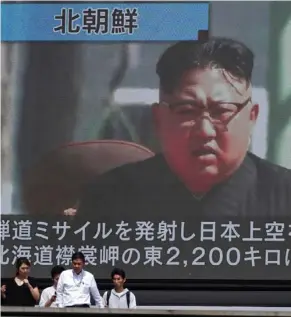  ?? (Photo by Eugene Hoshiko, AP) ?? People walk past a public TV screen showing a file footage of North Korean leader Kim Jong Un during news on North's missile launch, in Tokyo, Friday, Sept. 15, 2017. North Korea fired an intermedia­te-range missile over Japan into the northern Pacific...