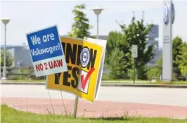  ?? ?? Signs for and against the union drive in 2019 are shown in a roundabout along Volkswagen Drive in front of the Volkswagen production plant in Chattanoog­a. The UAW lost the election.