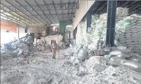  ?? AP ?? Police inspect the salt packaging factory after its wall collapsed in Morbi district on Wednesday.