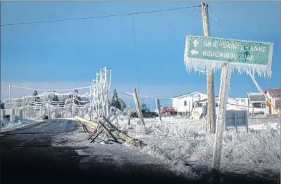  ?? CP PHOTO ?? Downed power poles and an ice covered sign are shown in Escuminac, N.B., on Friday, Jan. 27, 2017. A review of a devastatin­g ice storm in New Brunswick that left two people dead and more than 130,000 people without power says the provincial government...