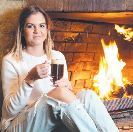  ??  ?? Brittany Benton enjoying an Irish coffee in front of the D’Arcy Arms fire. Picture: Richard Gosling