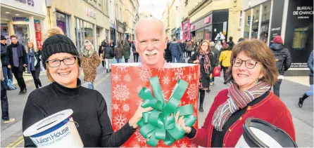  ??  ?? Volunteer Christine Harrison, left, and Allison Herbert, chief executive of Bath BID, with Julian House fundraisin­g director Cecil Weir marking the end of the gift wrapping service