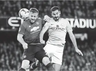  ?? DAVE THOMPSON
THE ASSOCIATED PRESS ?? Manchester United’s Luke Shaw, left, and Manchester City’s Ilkay Gundogan challenge for the ball during the English Premier League soccer match between the crosstown rivals Sunday at the Etihad stadium.