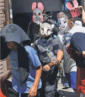  ?? ROBERT DEUTSCH/USA TODAY ?? Children are escorted out of the Cayuga Centers facility in East Harlem on Thursday. The masks made it impossible to tell which had been separated from their parents at the U.S.-Mexico border.