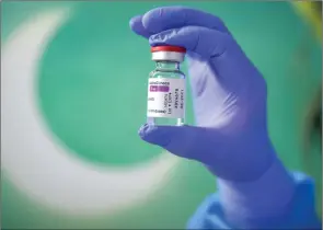  ?? The Associated Press ?? Medical staff display a container of AstraZenec­a vaccine in Bucharest, Romania, on Monday. The Canadian government has yet to approve the vaccine.