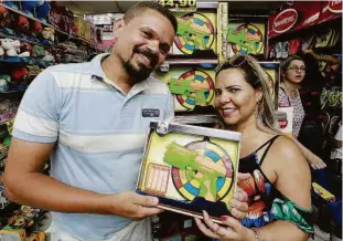  ?? Robson Ventura/folhapress ?? Moradores do Guarujá, Luciano de Jesus, 37, e Nívea de Jesus, 42, comemoram o preço mais baixo do brinquedo do filho, comprado na região central da capital