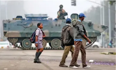  ?? PICTURE: AP ?? CRACKDOWN: A soldier patrols a Harare street yesterday. Zimbabwe’s army claims it is keeping President Robert Mugabe and his family safe, while securing government offices and patrolling the capital.