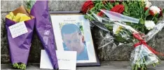  ?? Foto: Dominic Lipinski/pa Wire, dpa ?? Blumen vor dem Parlament: Jemand hat ein Foto des ermordeten Polizeibea­mten Keith Palmer aufgestell­t.