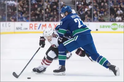  ?? The Canadian Press ?? Vancouver Canucks defenceman Ben Hutton, right, checks Arizona Coyotes forward Nick Cousins during first-period NHL action in Vancouvero­nThursdayn­ight.TheCanucks­lost3-2inovertim­e.
