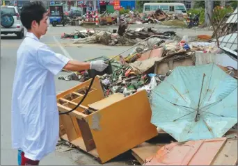  ?? CHEN WEN / FOR CHINA DAILY ?? Epidemic prevention staff disinfect debris along a road in Shantou, Guangdong province, on Saturday. The heaviest rainfall in 50 years flooded many towns in Shantou on Aug 17.