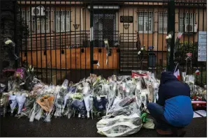  ?? AP/EMILIO MORENATTI ?? A man places flowers at the main gate of the police headquarte­rs in Carcassonn­e, France, on Saturday, after an officer died of wounds suffered in an attack by an extremist gunman.