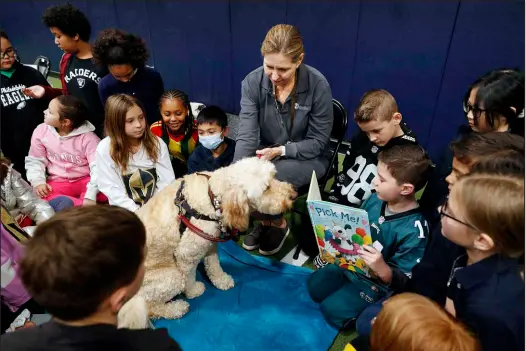  ?? PHOTOS BY STEVE MARCUS ?? A third-grader reads to Lucy, a 4-year-old goldendood­le, during a Nevada Reading Week event Wednesday at Legacy Traditiona­l School. Stephanie Brown, a Pet Partners of Las Vegas handler, is at center. Having Lucy in the class puts the children at ease, which helps with their reading skills and public speaking.