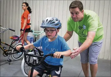  ?? NICK WAGNER/AMERICAN-STATESMAN PHOTOS ?? Will Suter gets going with the help of volunteer Jacob Rutledge during bike camp.