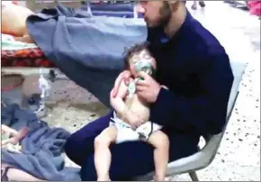  ?? SYRIA CIVIL DEFENCE/AFP ?? An image grab taken from a video shows unidentifi­ed volunteers giving aid to children at a hospital following an alleged chemical attack on the rebel-held town of Douma earlier this month.