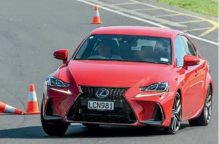  ??  ?? A Lexus IS350 F Sport leans on its front suspension as it takes on a slalom course.