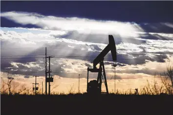  ?? ELI HARTMAN/MEMBER IMAGE SHARE, ASSOCIATED PRESS ?? The sun shines through the clouds as it begins to set behind a pumpjack in March 2022 outside of Goldsmith, Texas.