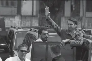  ?? AP/LEO CORREA ?? Brazilian presidenti­al candidate Jair Bolsonaro of the far-right Social Liberal Party waves to supporters Sunday after voting at a polling station in Rio de Janeiro.