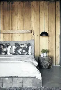  ??  ?? Rudi and his team made the built-in bed and created the simple varnished tree stumps that are used as bedside tables. A chunky wooden shelf doubles as storage and the housing for the bedside light switches.
