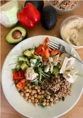  ?? Gretchen McKay/Post-Gazette ?? This menopause-friendly Protein Power Bowl pairs protein- and fiber-rich farro with low-fat roasted chicken, avocado and lemon hummus on a bed of salad greens.