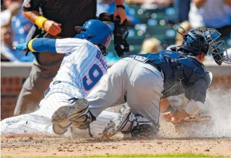  ?? THE ASSOCIATED PRESS ?? Chicago Cubs second baseman Javier Baez, left, slides safely into home past Atlanta Braves catcher Kurt Suzuki during Friday’s game in Chicago.