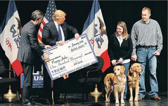  ?? PAUL SANCYA / AP ?? Trump entregando un cheque gigante a una organizaci­ón de apoyo a los veteranos en Iowa, en enero del 2016, en campaña electoral