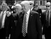  ?? MARY ALTAFFER / AP ?? Republican presidenti­al candidate Donald Trump, center right, and Republican vice presidenti­al candidate Gov. Mike Pence, R-Ind., center left, walk toward supporters Wednesday after Trump arrived via helicopter in Cleveland.