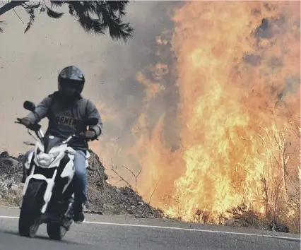  ?? 0 A forest fire rages just six miles from the Honduran capital Tegucigalp­a earlier this month ??