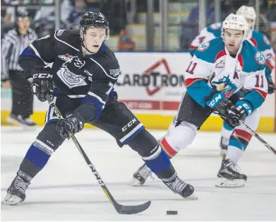  ?? DARREN STONE, TIMES COLONIST ?? Royals defenceman Scott Walford tries to dish off a pass while under pressure from Rockets forward Eric Gardiner during first-period action at Save-on-Foods Memorial Centre on Friday.