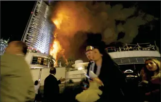 ??  ?? Panic: Terrified tourists run for their lives as smoke and flames engulf the building