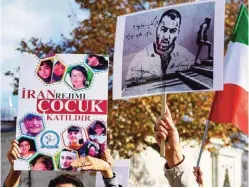  ?? ?? People hold placards bearing portraits of Iranian rapper Toomaj Salehi (right), who is arrested in Iran, and portraits of children (left), who were killed during the protests in Iran, during a rally in support of Iranian women in Istanbul.-AFP