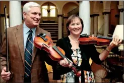  ?? Arkansas Democrat-Gazette/JOHN SYKES JR. ?? Opus Ball co-chairmen Nick and Susan Brown give violins a try. As longtime Arkansas Symphony Orchestra supporters, this is the Browns’ first time to direct the ASO’s annual fundraiser, which supports the organizati­on’s general operating budget.