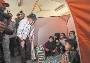  ?? ?? Hello there: ahmad Zahid visiting flood victims at SK nibong in Kuala berang. — bernama