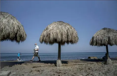  ?? Ramon Espinosa/Associated Press ?? The Caribbean is hunting for visitors and vaccines to jump-start the stalled economy in one of the world’s most tourism-dependent regions. The beach in Havana, Cuba, above, is uncrowded on Tuesday.