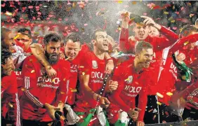  ??  ?? > The Wales squad celebrate reaching next summer’s Euro 2016 finals